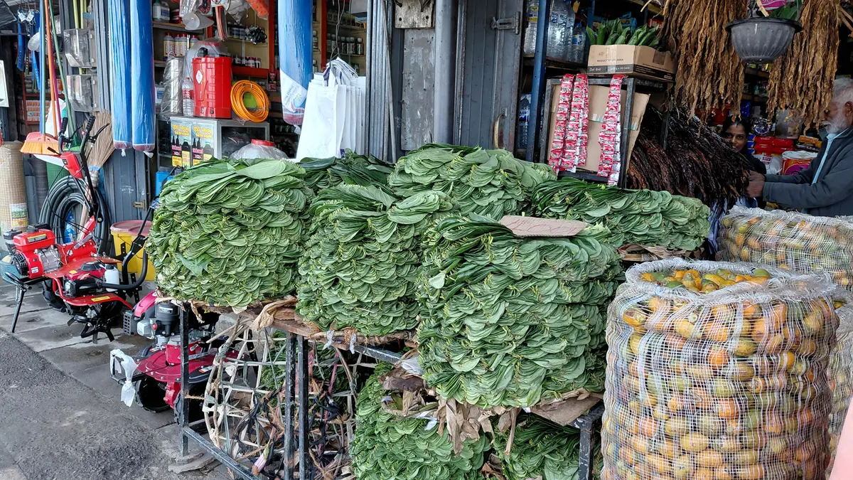 Leafy produce stacked at a market stall.