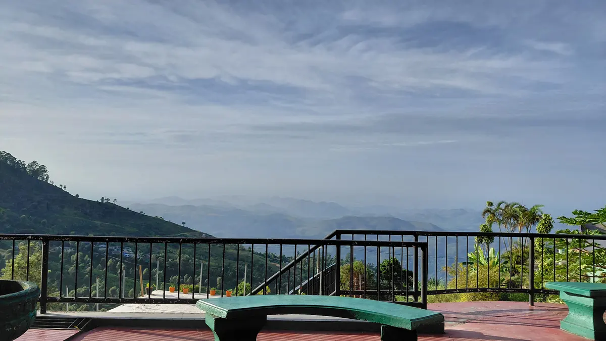 Terrace railing and seating overlooking distant hills.